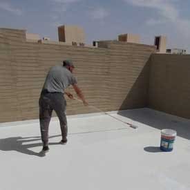 عامل يقوم بعزل سطح خرساني