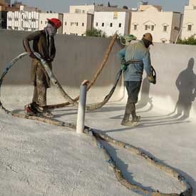 عمال يقومون برش عزل فوم على سطح
