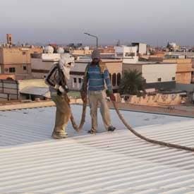 عمال يقومون بعزل سطح هنجر